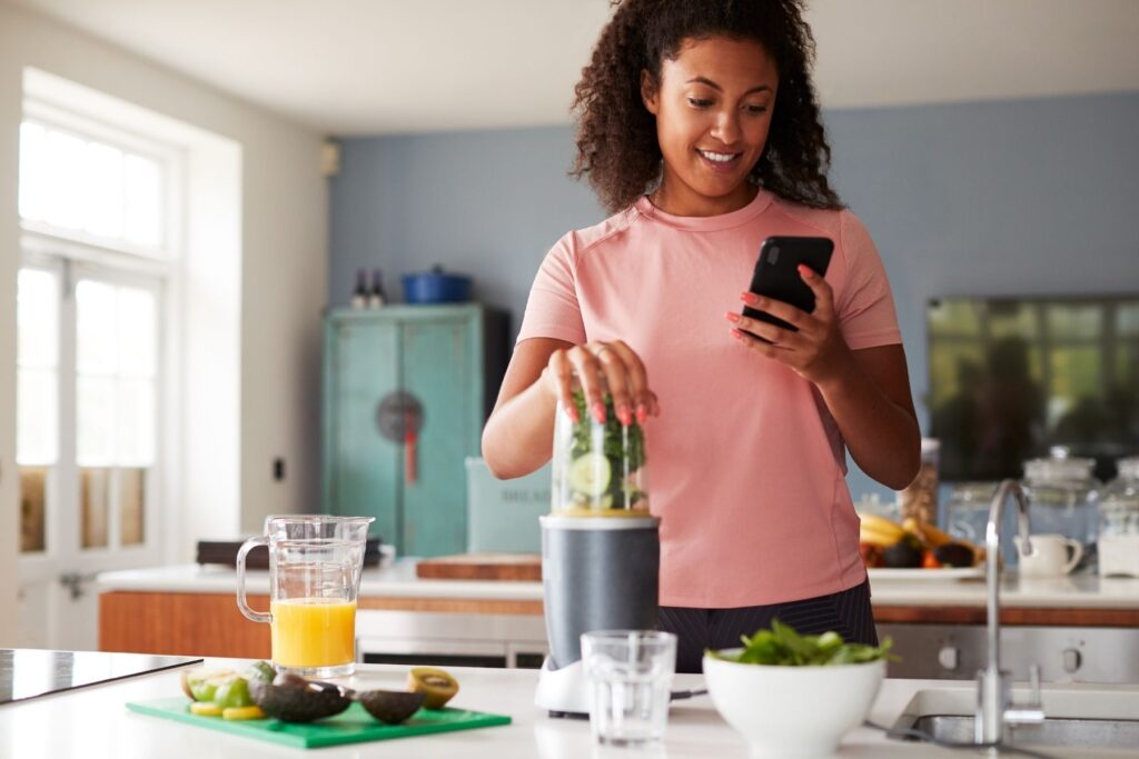 Lady Counting Calories While Blending